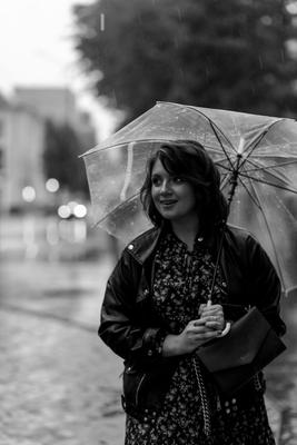 Foto Stock Девушка смеется под дождем. Сильный дождь, девушка держит  зонтик. Девушка в легком платье, весело смеется. Падают осенние листья.  Осень, осенний дождь | Adobe Stock