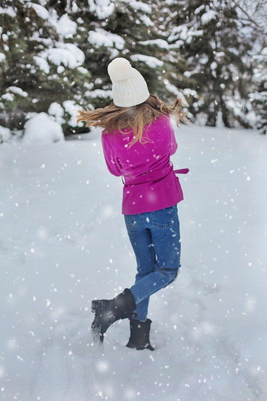 Девочка в холодных взглядах на варежки и улыбках снега. Зима идет снег  ребенка на открытом воздухе. Теплая одежда, Стоковое Фото - изображение  насчитывающей рождество, шерсть: 208382556