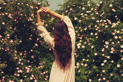 Красивая девушка-весна — с цветами в волосах, спиной без лица на аву