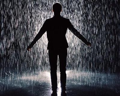 Человек, стоящий под дождем с камерой на капюшоне | Премиум Фото